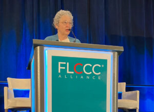 Dr Meryl Nass stands at podium during FLCCC conference